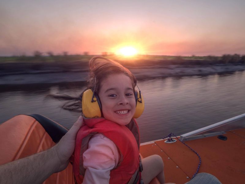 Happy child on airboat ride durning sunset in central florida